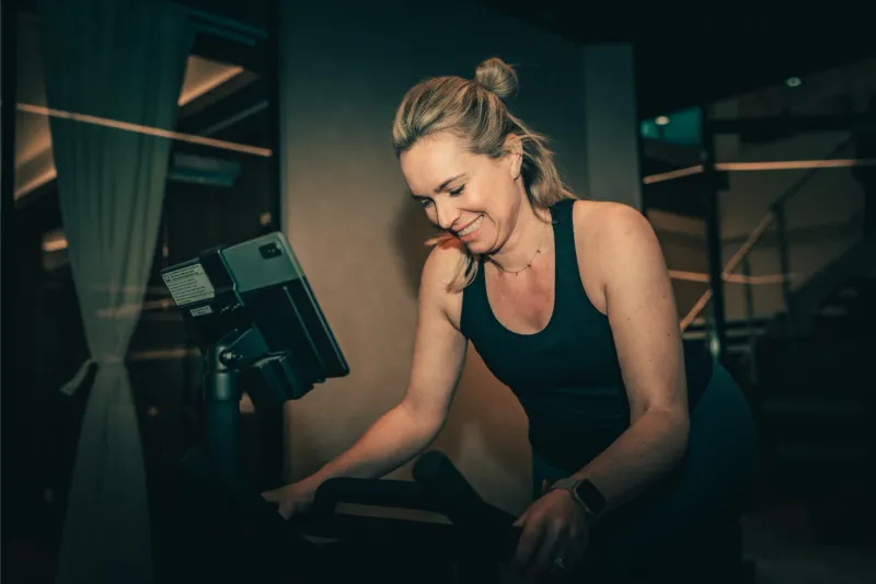 A member smiles while training on a machine at The FIT Partnership