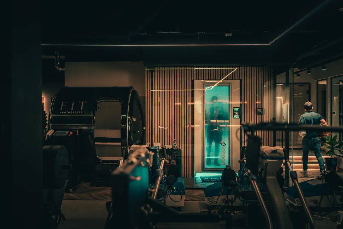 The studio floor at The FIT Partnership, with the hyperbaric oxygen chamber and the cryotherapy chamber glowing blue